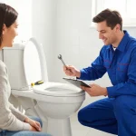 Apex Plumbing Services Sutherland Shire plumber inspecting a toilet repair in a bright bathroom environment, showcasing professionalism.