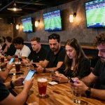 Betting enthusiasts analyzing odds at keonhacaii88 in a vibrant sports bar setting