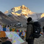 Everest Base Camp Trek with Helicopter Return adventure scene featuring traveler at sunrise.